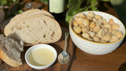 Macadamia oil in a bowl with sour dough, ready for dipping. Accompanied with natural raw macadamia nuts.